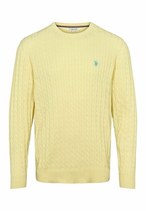 Keltainen neulepusero, jossa on pintakuviointi, ribatut hihansuut ja helma, sekä pieni sininen logo vasemmassa rinnassa. Pehmeä rakenne ja klassinen muotoilu.