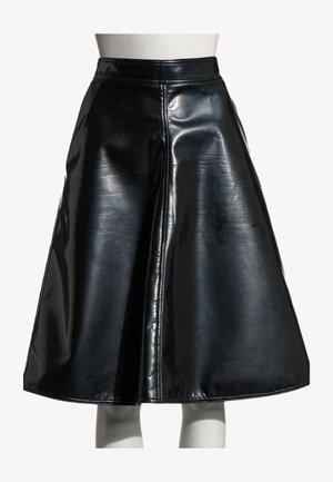 Jupe trapèze en similicuir noir brillant avec une couture verticale visible au centre, portée sur un mannequin avec un fond blanc.