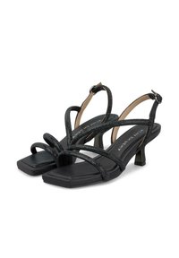 Sandalias negras con tiras y pequeños tacones cuadrados. Las tiras texturizadas se entrelazan sobre un diseño de punta cuadrada y lisa. Detalle de hebilla ajustable en el tobillo.