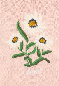 Pink textile with embroidered white daisies featuring yellow centers and green leaves. Includes “bon ton” in white stitching at the bottom.