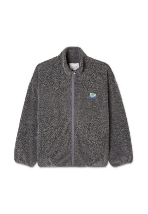 Veste en polaire grise avec fermeture éclair devant, col haut et surface texturée. Présente un petit patch logo multicolore sur la poitrine gauche.