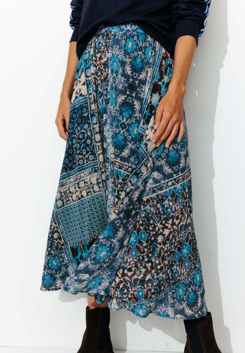 Jupe maxi multicolore, bleu et marron, avec des motifs floraux et géométriques, dotée d'une taille élastique et d'un tissu fluide.