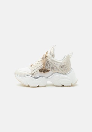 Άσπρο chunky sneaker με λεπτομέρειες λεοπάρ, χοντρή σκαλιστή σόλα και χρυσό charm "Buffalo" στα κορδόνια σε απλό φωτεινό φόντο.