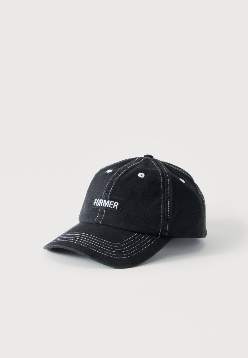 Schwarze Baseballkappe mit weißen Nähten und dem Wort "FORMER" auf dem Frontpanel gestickt, vor hellem einfarbigem Hintergrund.