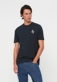 Dark blue short-sleeve t-shirt made of cotton, featuring a small embroidered logo on the chest and a round neckline.