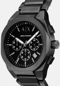 Reloj cronógrafo de acero inoxidable negro con una audaz caja octagonal, marcadores de hora blancos y tres subesferas. Presenta una pantalla de fecha y un logotipo.