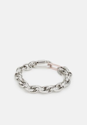 Kraftig sølvkjedearmbånd med glatte, avrundede lenker, et rosa aksentgummielement og en avtakbar karabinkrok.