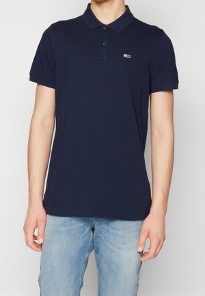 Polo bleu marine en coton, doté d'un col et de manches courtes, avec un petit logo sur la poitrine.