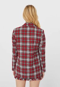 Rood-wit geruite blazer met lange mouwen, sluiting met één knop en rafelige zoomdetails aan de onderkant. Textuurstof afwerking.