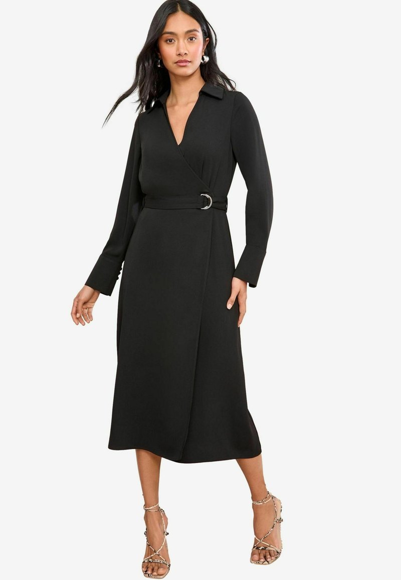 Schwarzes Wrap-Kleid mit Kragen, langen Ärmeln und einem silbernen Ringgürtel-Detail, das eine fließende Silhouette und eine weiche Textur aufweist.