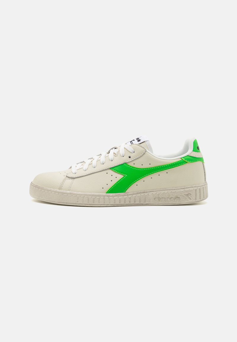 Sneaker in pelle bianca con un brillante logo swoosh verde, suola in gomma texturizzata e design tradizionale con lacci e perforazioni.