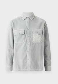 Light gray corduroy shirt with two buttoned chest pockets, a collar, and long sleeves. Textured fabric with vertical stripes and subtle sheen.