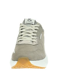 Sneaker da uomo con una tomaia in suede beige, accenti bianchi e lacci beige. Presenta una suola in gomma con un motivo testurizzato e un dettaglio del logo.