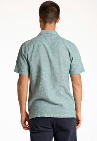 Korte mouw shirt in licht teal, gemaakt van een gestructureerde stof. Voorzien van een kraag en een rechte zoom, met een relaxte pasvorm die geschikt is voor casual draag.