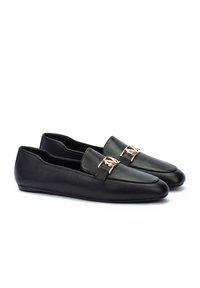 Mocasines de cuero negro con puntera puntiaguda, con un acento de hardware dorado en el empeine. Textura suave y diseño de perfil bajo.