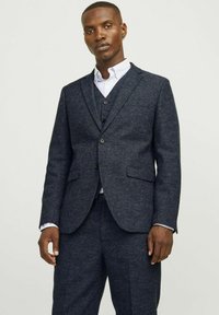 Marineblauer Anzug mit strukturiertem Finish, bestehend aus einem Blazer, einer Weste und passender Hose. Einreiher mit drei Knöpfen und Taschen.