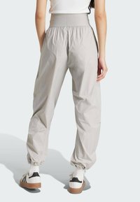 Svetlošedé, elastické nohavice s elastickým pásom, zoštíhlenými manžetami a hladkou textúrou. Majú uvoľnený, voľný strih.