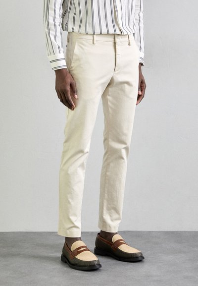 Pantaloni din bumbac bej cu o croială dreaptă, buzunare laterale și o textură netedă. Asortați cu pantofi loafers bicolor cu un design țesut.
