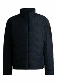 Marinblå vadderad jacka med ståkrage, dragkedja och diagonala sömdetaljer. Inkluderar en ficka med dragkedja på vänster ärm.