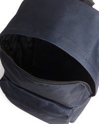 Tumesinine seljakott avatud põhiosa ja esikülje tõmblukuga taskuga, näidates musta sisemust ja vastupidavat kangast tekstuuri.