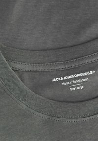 Hall hallide t-särk, ümmarguse kaeluse ja õmmeldud servadega, millel on silt "JACK & JONES ORIGINALS", suurus Suur ja päritoluriik.