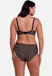 Ensemble soutien-gorge et culotte imprimé léopard en tan et noir. Doté de bretelles réglables, d'une fermeture à crochet et d'un tissu lisse et extensible.
