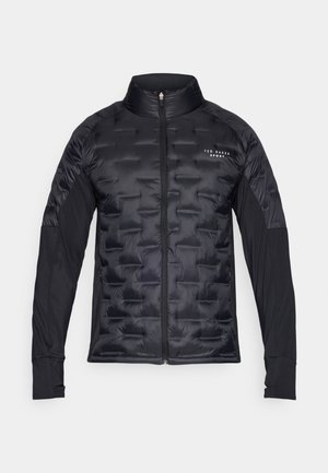 Chaqueta de abrigo negra con textura acolchada en el pecho, mangas de tela suave, cuello alto y cremallera frontal. Presenta el logo de la marca en el pecho.