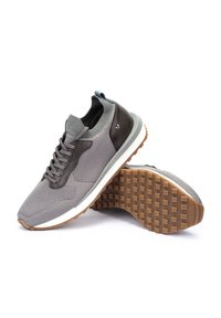 Zapatillas deportivas grises con parte superior de malla, acentos de cuero y suela de goma con un patrón texturizado para mayor agarre. Diseño de perfil bajo con cordones.