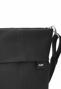 Borsa in pelle nera con design a cima arrotolata, caratterizzata da una texture liscia, una tracolla e un piccolo etichetta cucita sulla parte anteriore.
