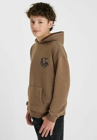 Bruine hoodie met een voorzak, verstelbare trekkoordkap en een logo print in donkerblauw op de borst. Zacht katoenen materiaal, relaxte pasvorm.