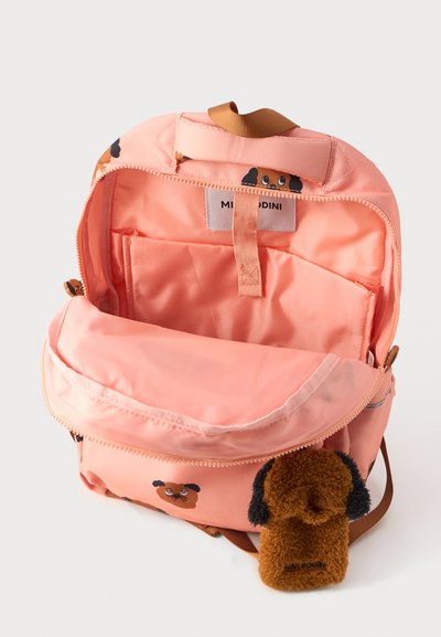 Mochila de tela rosa con motivos de perros juguetones. Cuenta con un amplio compartimento principal y un bolsillo más pequeño con un tirador de cremallera en forma de perro peludo.