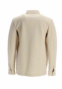 Chemise beige texturée à manches longues vue de dos avec col et poignets boutonnés sur fond blanc.