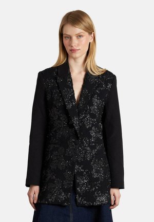 Blazer negro con bordado de lentejuelas florales en la parte frontal, mangas de tela suave y cierre de un solo botón, con un cuello con muesca.
