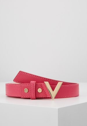 Roze getailleerde leren riem met gouden V-vormige gesp en bijpassende gouden studs, opgerold tentoongesteld op een witte ondergrond.