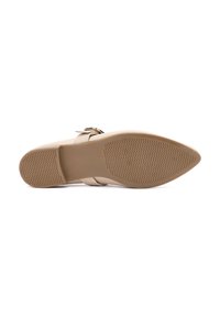 Zapato plano nude con suela de goma texturizada, puntera afilada y correa ajustable con un acento de hebilla metálica.