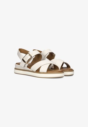 Witte leren sandalen met kruislingse banden en een achterste gesp. Dikke witte zool met een tan kleurige voetbed. Open teenontwerp.