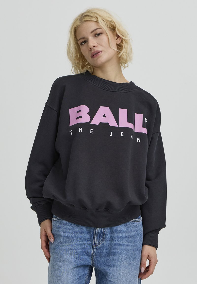 Sweat-shirt gris foncé avec logo graphique "BALL" en rose, poignets et taille côtelés. Design décontracté, texture douce, coupe ample.