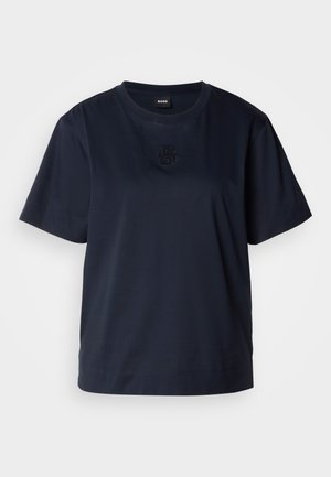 T-shirt bleu marine à manches courtes en coton doux. Il présente un col rond et un logo brodé subtil sur la poitrine.