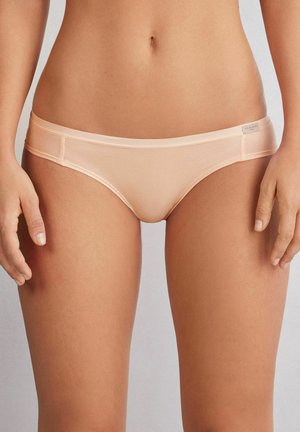 Lichtroze low-rise bikini ondergoed van gladde stof met een minimalistisch ontwerp, voorzien van een subtiele tailleband en een label aan de zijkant.