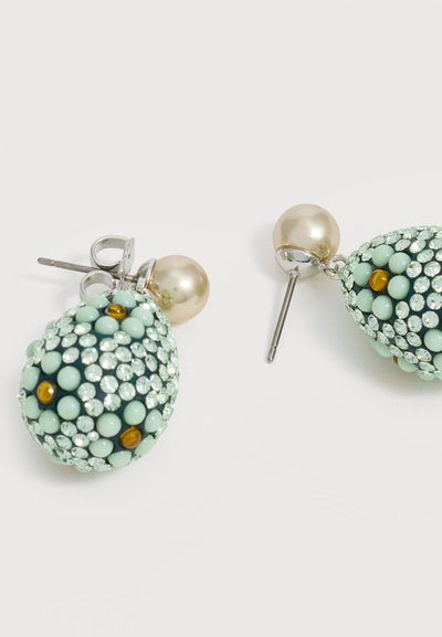 Paire de boucles d’oreilles pendantes avec clous en perle et pendentifs en forme de goutte ornés de perles bleu clair, de cristaux transparents et d’accents ambrés.