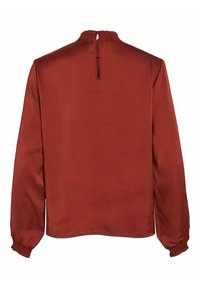 Blouse à manches longues couleur rouille avec col montant froncé, ouverture en forme de goutte dans le dos et poignets smockés sur les manches.