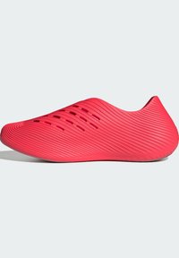 Κόκκινο παπούτσι τύπου slip-on με υφασμένα διαγώνια μοτίβα και σχισμές αερισμού στο πάνω μέρος, εμφανίζεται σε απλό φωτεινό φόντο.