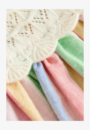 Pletený top s jemným bielym čipkovým lemom, ktorý má multikolórovú prúžkovanú látku v pastelových odtieňoch ružovej, zelenej, modrej, žltej a krémovej. Mäkčené textúry.