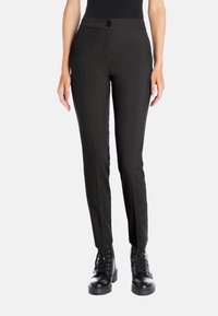 Black tailored pants with a fitted design, flat front, and button closure, made of textured fabric; paired with black lace-up boots.