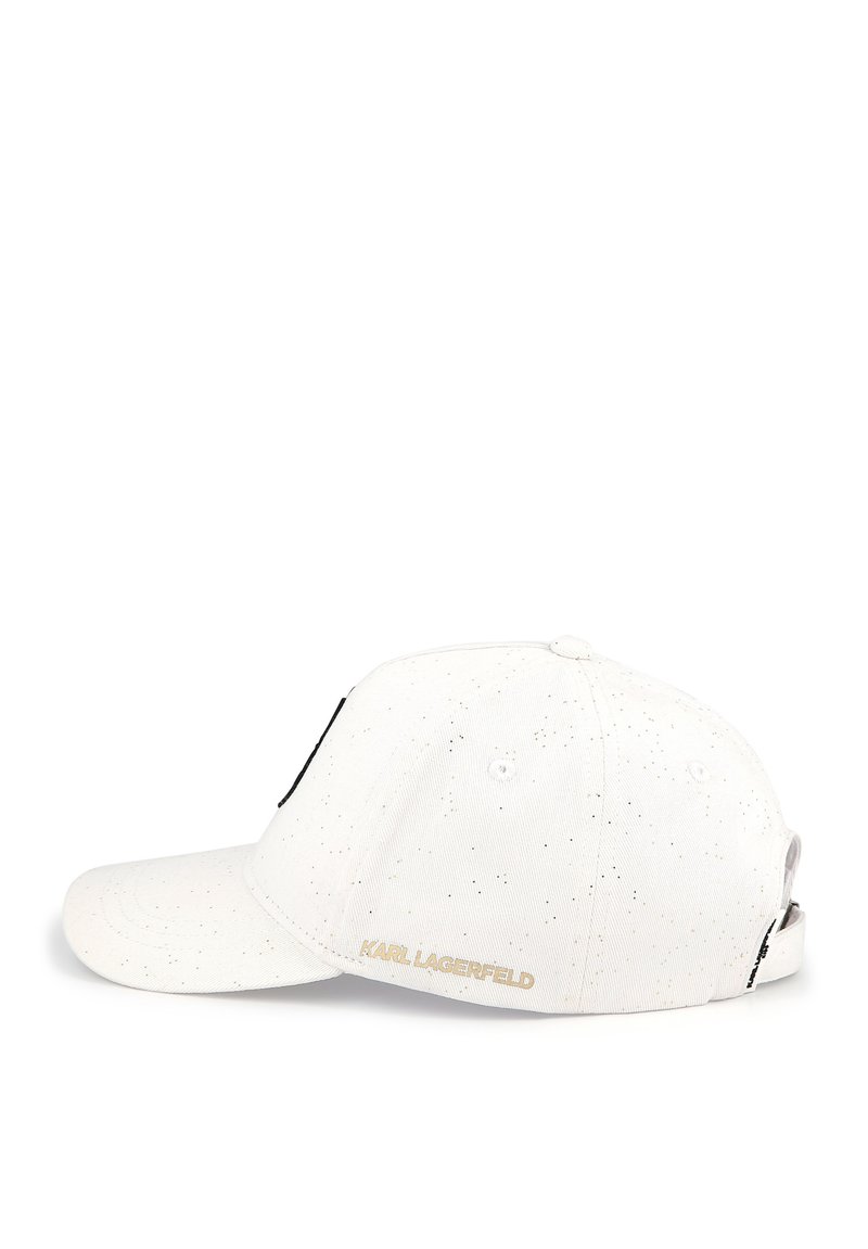 Gorra de béisbol blanca con textura moteada, con un acento negro y el logo dorado "KARL LAGERFELD" en la parte trasera. Diseño de visera curva.