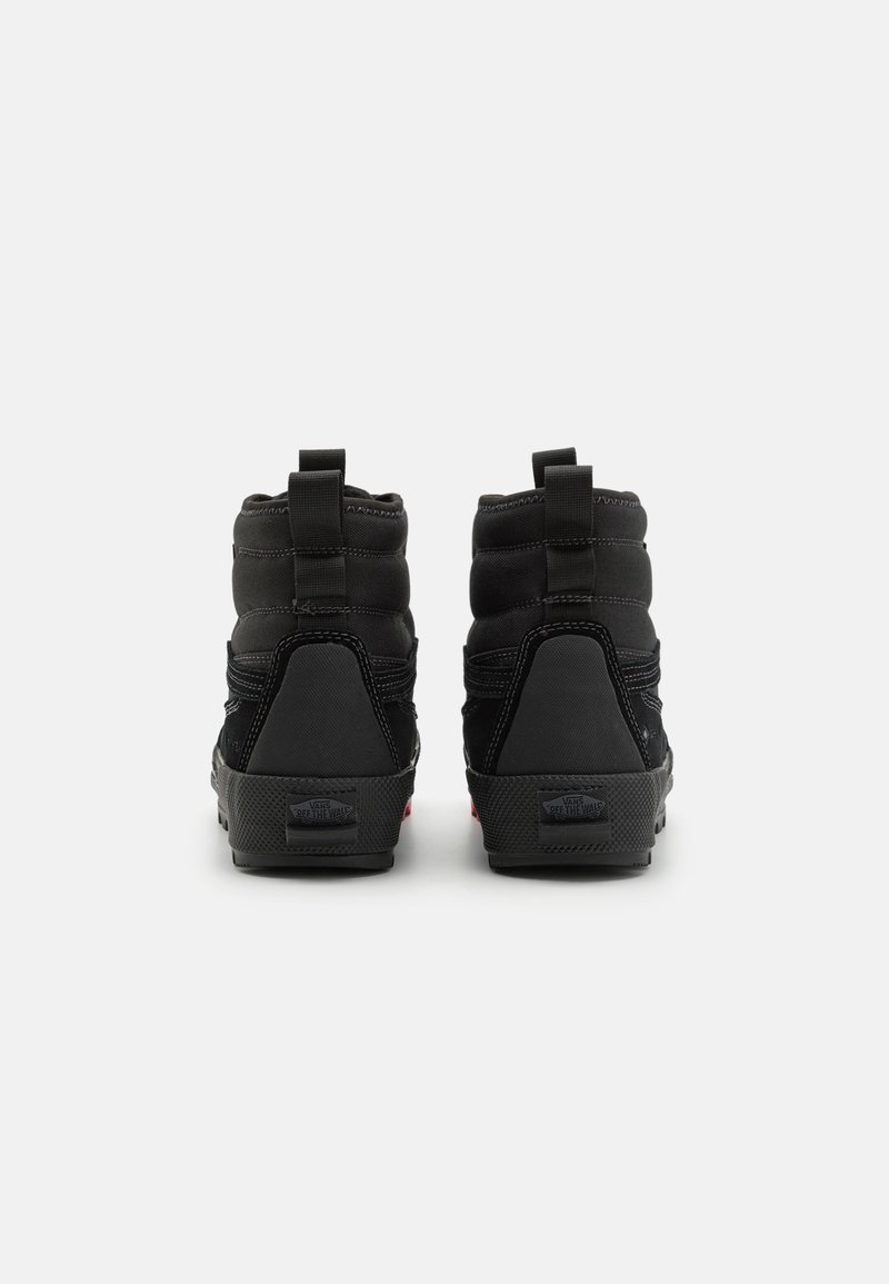 Czarne sneakersy typu high-top z wyściełanym kołnierzem, teksturowanym materiałem, gumową podeszwą, tylnymi uchwytami ułatwiającymi zakładanie i zdejmowanie oraz logo Vans na pięcie.