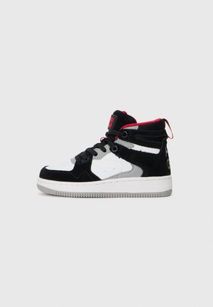 Black and white mid-top sneakers with suede and mesh materials. Features red accents, gray detailing, and a textured rubber sole.