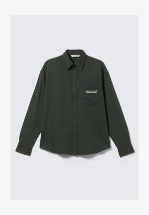 Dark green long-sleeve button-up shirt with collar and chest pocket labeled "ATHLETIX DEPT" on a plain light background.