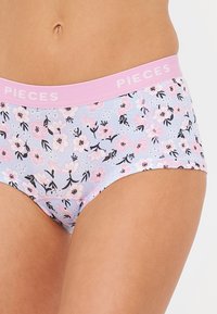 Ondergoed met bloemenpatroon in lichtblauw, met een roze tailleband waarop het woord "PIECES" staat. Gemaakt van zachte katoen met zwarte bloemenaccenten.
