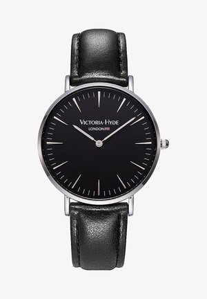 Schwarze analoge Uhr mit einem runden Gehäuse aus Edelstahl, silbernen Anzeigen und einem schwarzen Lederarmband. Merkmale ein minimalistisches Design und das Markenlogo.